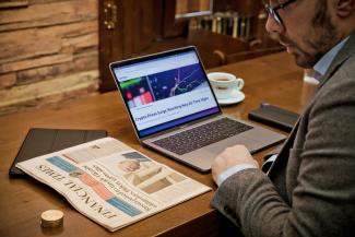 a man sitting at a desk with a laptop computer by Sortter courtesy of Unsplash.